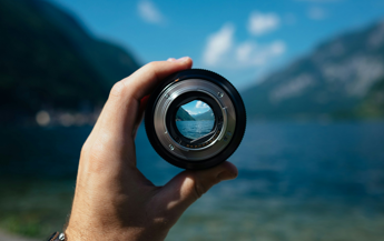 Person mit Fernglas an einem See